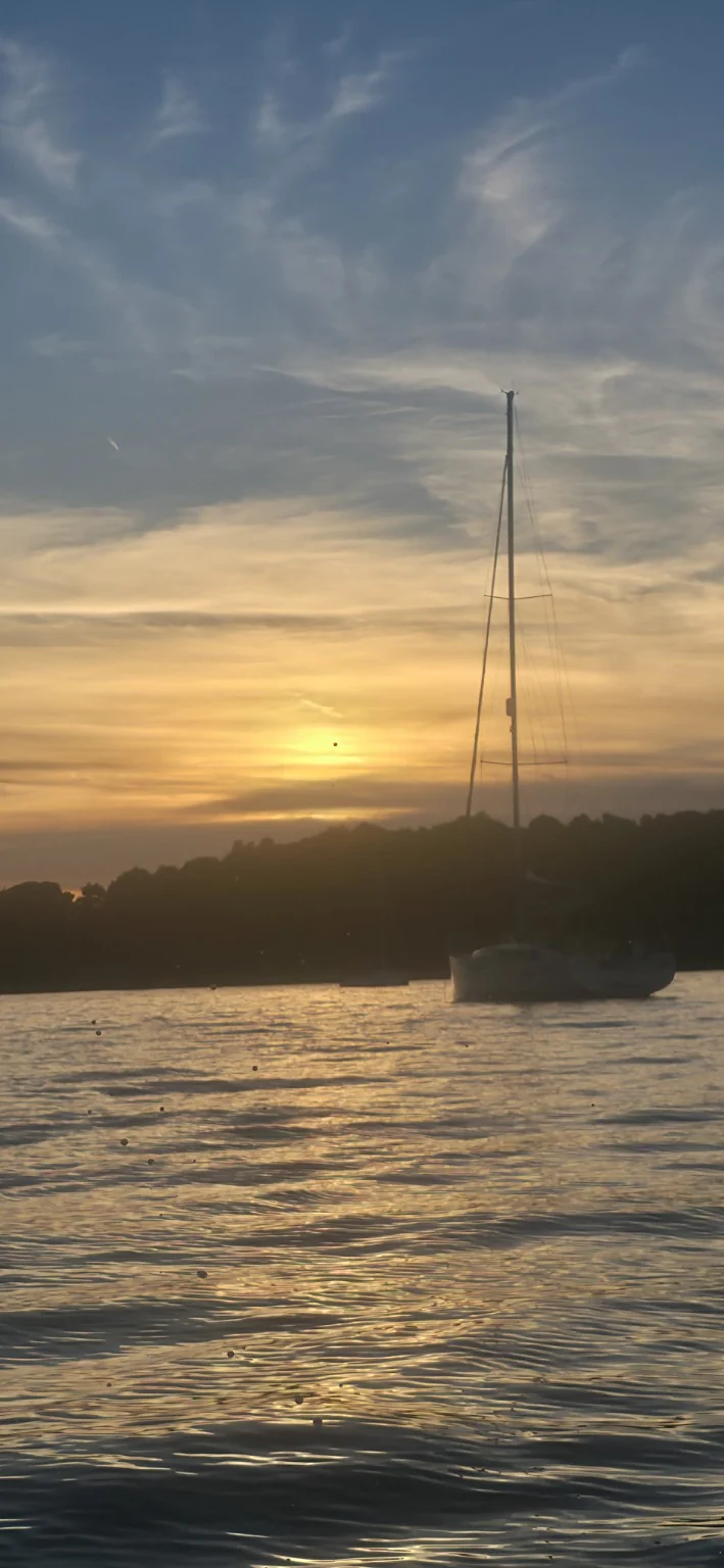 Sailing yacht silhouetted against a golden sunset, part of the Task-B Orange Chapter